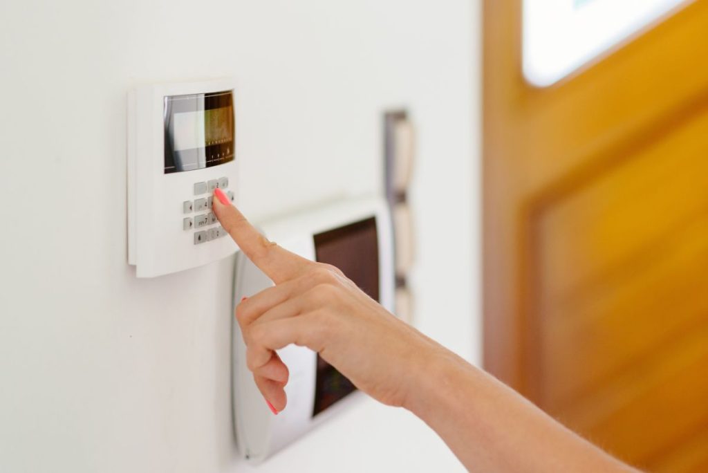 a homeowner setting their home security system to feel secure in a new home