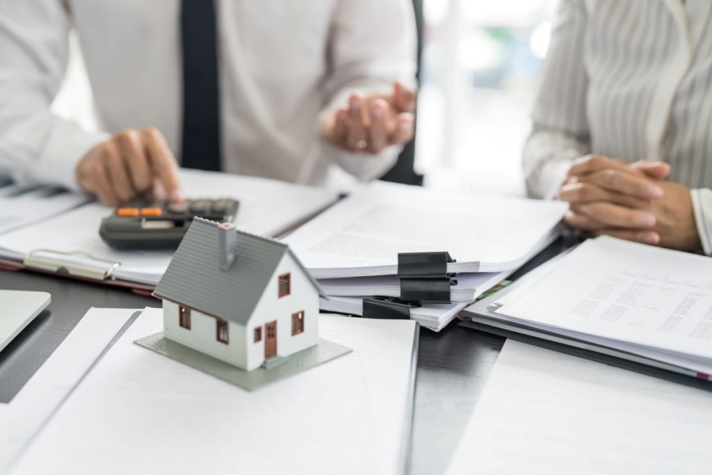Home security consultant reviewing system costs and installation documents with a homeowner